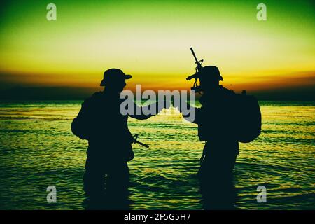 Silhouette of soldiers celebrating with fist bump gestures while ...