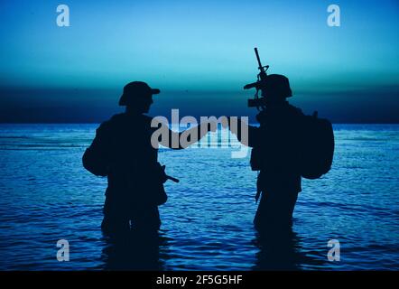 Silhouette of soldiers celebrating with fist bump gestures while ...