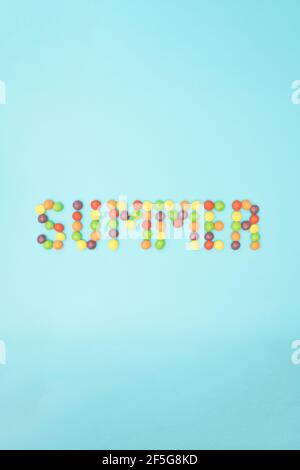 Summer word made from colored balls  on a blue vertical background. Tropical summer concept on a minimal background. Stock Photo