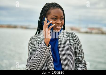 Young african american businesswoman smiling happy talking on the smartphone at the port. Stock Photo
