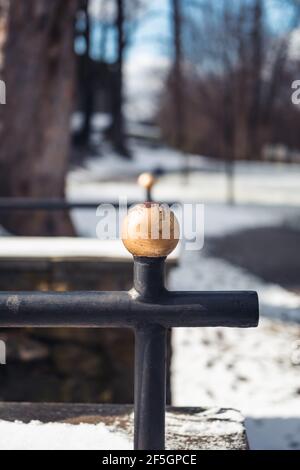 Detail of an old, steel, handrail in a park covered with snow during sunny day, Mikolow, Poland Stock Photo