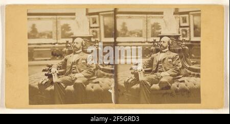 Close-up of bearded, bald gentleman seated on circular couch in his private art gallery, holding a carte-de-visite album. Unknown maker, American Stock Photo