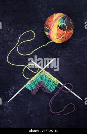Multi coloured wool with knitting on textured background Stock Photo