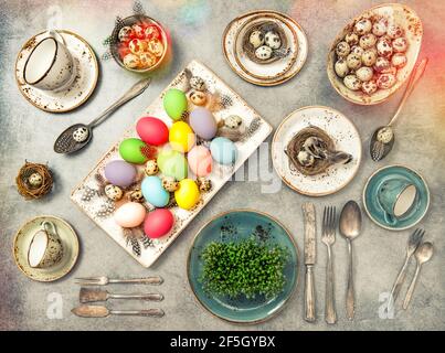Easter flat lay with colored eggs. Festive table place setting decoration. Vintage style toned picture Stock Photo