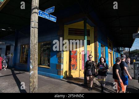 People stroll past the colorful, graffiti-adorned buildings on the vibrant Frenchmen Street in New Orleans' Marigny. Stock Photo