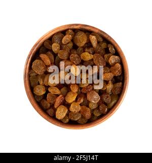 Heap of sweet raisins in wood bowl isolated on white background. Dried grapes pile, top view Stock Photo