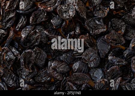 Dried plums or prunes fruit background texture. Heap of sun dried fruits plums. Top view. Stock Photo