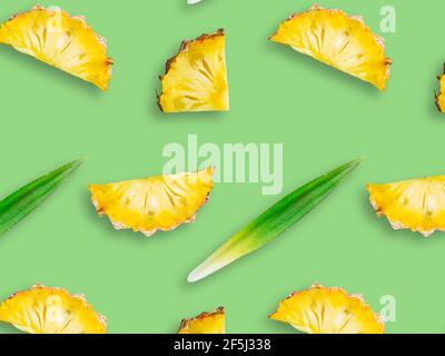 Seamless pattern of fresh ripe pineapple slices isolated on green background Stock Photo