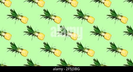 Seamless pattern of fresh ripe pineapple halves isolated on green background. Top view. Exotic tropical fruit summer concept. Stock Photo