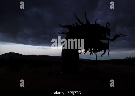 Borrego Springs, CA. March 23, 2021. A 350-foot long sculpture of a dragon-serpent b Mexican artist Ricardo Breceda under a stormy sky. Stock Photo