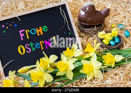 Easter, decoration on the straw. Chocolate Easter egg hen, and slate with german inscription "Happy Easter". "Frohe Ostern" Stock Photo
