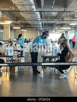 Frisco TX, USA - March 26, 2021: Indoor view of hospital assistants helping people registering the covid-19 vaccine Stock Photo