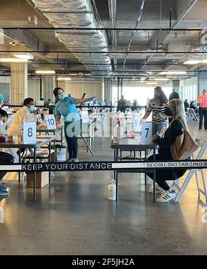 Frisco TX, USA - March 26, 2021: Indoor view of people registering the covid-19 vaccine with keep distance belt Stock Photo