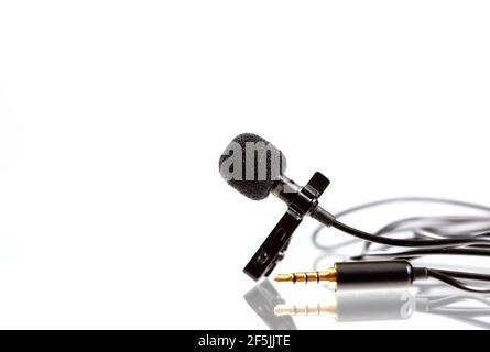 Small lavalier microphone or lapel mic on white background. Professional sound recording equipment for cell phone. Stock Photo