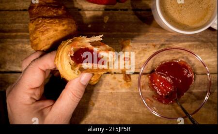 Eating freshly baked French croissants for breakfast Stock Photo