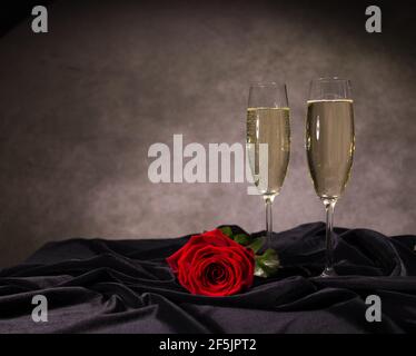 Sparkling wine and red roses in close-up Stock Photo