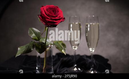 Sparkling wine and red roses in close-up Stock Photo