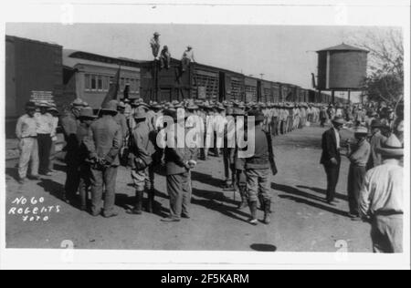 Railroad trains transporting Insurrectos during the Mexican Revolution- Side view with many soldiers standing alongside Stock Photo