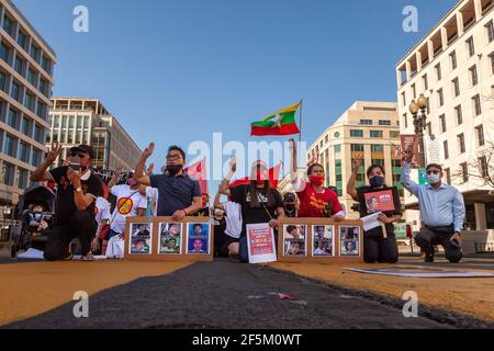 Washington, DC, USA, 26 March, 2021.  Pictured: People kneel at a protest against the Myanmar coup and raise three fingers to show support for democracy in Myanmar, as they demand US intervention to restore the elected government.  Credit: Allison C Bailey/Alamy Live News Stock Photo