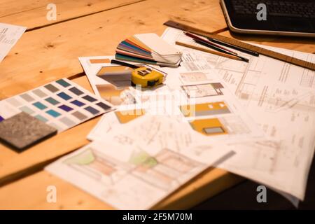 Blueprints and plans of a construction project with architect's tools: laptop, ruler, tape measure, pencils, pallets and samples of materials on a woo Stock Photo