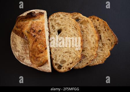Fresh sliced ​​whole grains bread on a black background. Two slices of sliced bread. View from above. Stock Photo