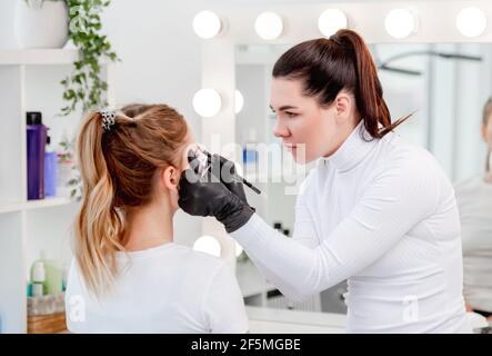 Master making eyebrows permanent makeup Stock Photo