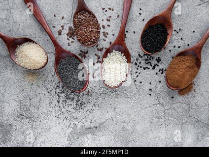 Wooden spoons with various healthy seeds and spices on gray concrete background Stock Photo