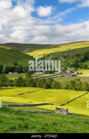 Picturesque Dales village houses, nestling in sunlit valley, fields, hills, hillsides, field walls & old barn ruin - Starbotton, Yorkshire England UK.