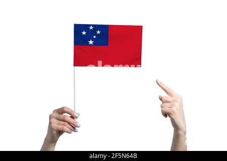 A beautiful female hand holds a Samoa flag to which she shows the finger of her other hand, isolated on white background. Stock Photo