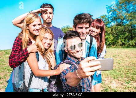 People group taking selfie at trekking excursion - Happy friendship and freedom concept with young millenial friends having fun together at camping Stock Photo