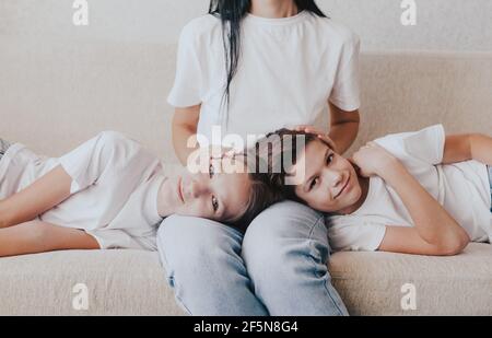 a large portrait of a boy and a girl lying on their mother's lap. Stock Photo