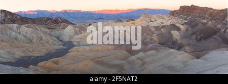 Panorama sunset or sunrise view of Zabriskie Point and the rugged sedimentary rock terrain of the badlands landscape in Death Valley Park National Par Stock Photo