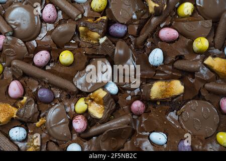 Home baking Easter concept. Brownie with chocolate bars, mini easter eggs and biscuits baked in. Chocolate feast home baked treat Stock Photo