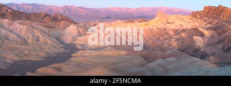 Panorama sunset or sunrise view of Zabriskie Point and the rugged sedimentary rock terrain of the badlands landscape in Death Valley Park National Par Stock Photo