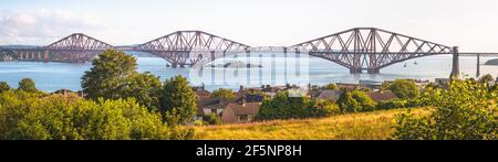 Wide panorama view of the iconic 19th century Forth Rail Bridge Queensferry Crossing over the Firth of Forth on a sunny day near Edinburgh, Scotland. Stock Photo