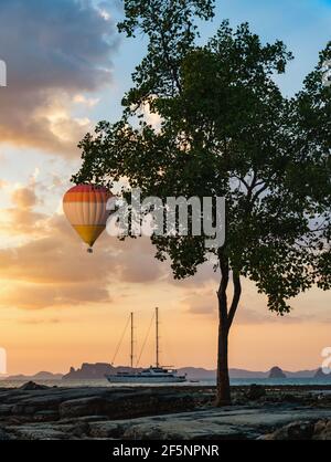 Thailand coastline, hot air balloon over sea and yacht in marine at sunset Stock Photo