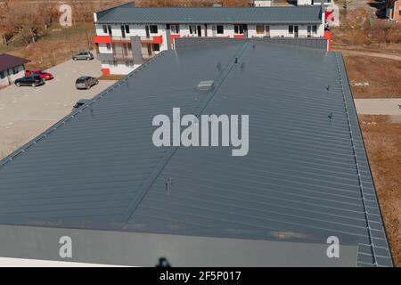 New tin roof on the apartment building. Watterproof roofing system Stock Photo