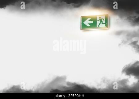 Emergency exit sign and fire smoke on the white wall background Stock Photo