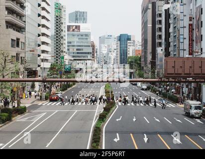 Shibuya, Tokyo, Japan - Busy people crossing at a crosswalk against a background of building forests. Stock Photo