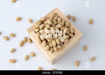 parched soy beans in measuring box isolated on white background Stock Photo