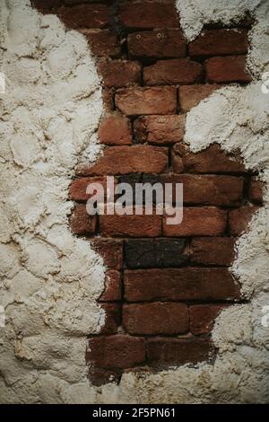 Vertical shot of a brick wall framed with rough concrete finishing Stock Photo