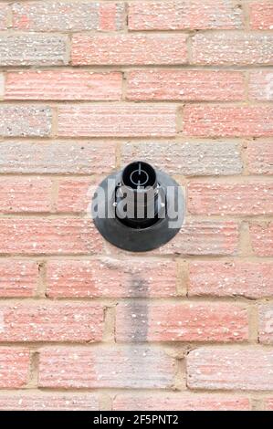 Front view of a gas boiler outlet in a red brick wall Stock Photo