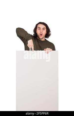 Astonished young man, positively surprised pointing index finger to blank announcement banner, looking amazed with big eyes and mouth open. Contented Stock Photo