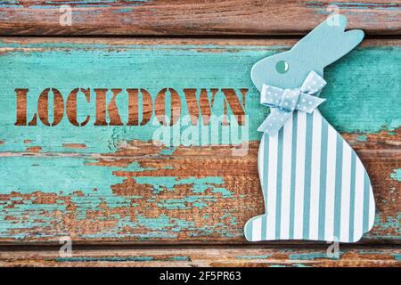 Lockdown and Easter bunny on wooden background Stock Photo