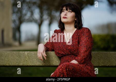 Portrait of a young parisian woman with a red dress and green eyes Stock Photo