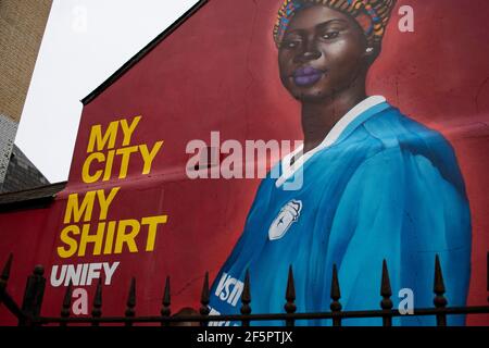 Cardiff, UK. 27th Mar, 2021. A Mural by artist Yusuf Ismail of a Pregnant Women in a Cardiff City football Shirt has appeared on the side of Mischiefs Cafe & Bar in Cardiff Bay, Wales pictured on the 27th March 2021. Credit: Lewis Mitchell/Alamy Live News Stock Photo