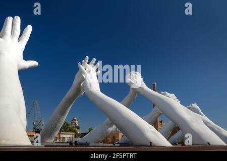 Big white hands sculpture Building Bridges by Lorenzo Quinn in the Biennale Art Exhibition Arsenale in Venice Stock Photo