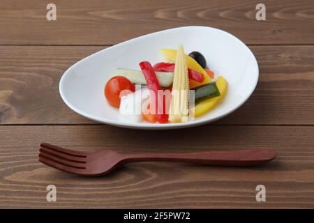 pickles pickled vegetables salad on plate isolated on wooden table Stock Photo
