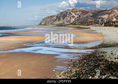 Penmaenmawr Beach, near the town of Penmaenmawr in North Wales, is a long sandy beach adjacent to the Menai Straits. Stock Photo