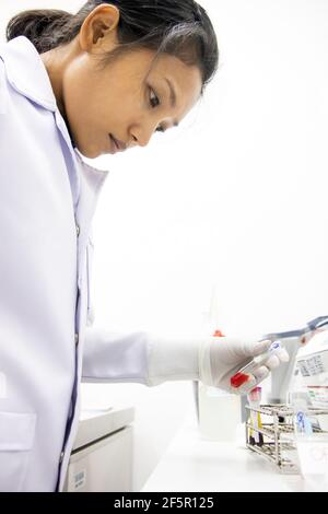 Doctor in lab examines the blood sample in a tube Stock Photo